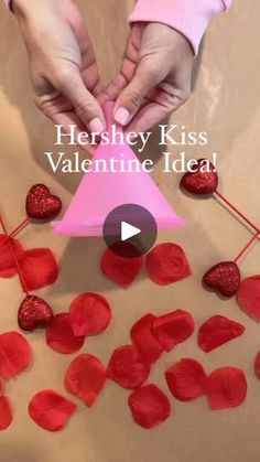 two people holding hands over red hearts on a sheet of paper with the words hershey kiss valentine's idea