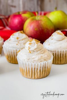 cupcakes with frosting and apples in the background