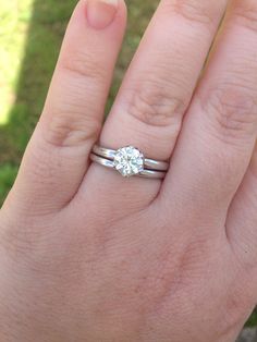 a person's hand with a ring on it and a diamond in the middle