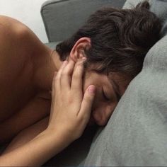 a man laying in bed with his hand on his face as if he were asleep