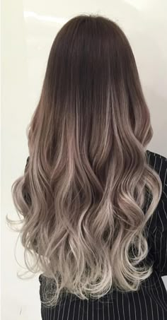 the back of a woman's head with long, wavy hair in grey tones