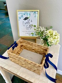 a basket sitting on top of a table next to a vase with flowers in it