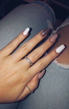 a woman's hand with white and pink manicures on her nails, sitting down