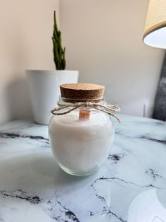 a jar filled with white liquid sitting on top of a table