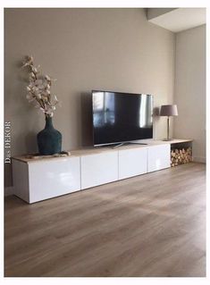 a flat screen tv sitting on top of a white entertainment center in a living room