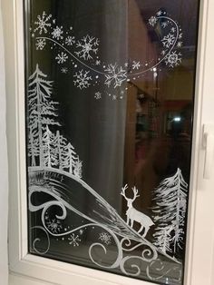 a frosted glass window with reindeer and snowflakes on the windowsills