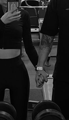 a man and woman holding hands in a gym