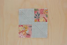 a piece of fabric that is on top of a wooden surface with flowers and leaves