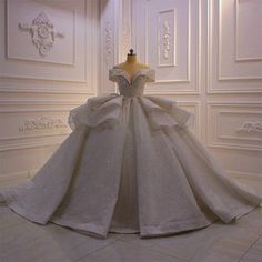 a white wedding dress on display in a room