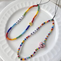 a white plate topped with two colorful beaded necklaces