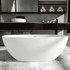 a large white bathtub sitting in front of a bathroom sink under a mirror next to a counter