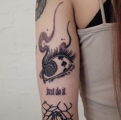 a woman with a tattoo on her arm that says just do it and an eyeball