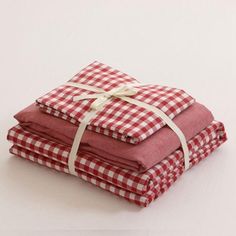 three folded red and white checkered cloths tied with twine on top of each other