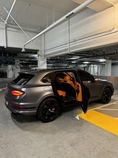 a car parked in a parking garage with its doors open and the door opened to show it's interior