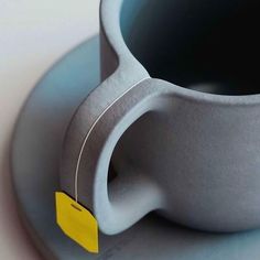 a cup with a yellow tag on it sitting on a saucer next to a plate