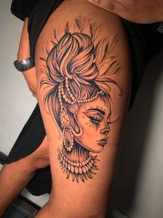 a woman's thigh with an intricate tattoo design on her leg and headdress