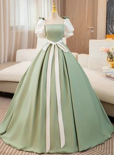 Magnificent in its simplicity and captivating in its design, isn't this sage green prom dress a stunning way to make an entrance? This beautifully crafted gown features a square neckline that sits just off the shoulders, offering a glimpse of elegance and sophistication. The bodice flows into a voluminous skirt, adorned with white satin ribbons that cascade down the length, adding a touch of grace and movement. The contrasting white puff sleeves balance the ensemble, creating a look that is both timeless and enchanting. Ideal for prom or any formal event, this dress ensures you'll be remembered not just for the night, but long after, as a vision in green and white. Green Long Prom Dress, White Prom Dress Long, Prom Dress Short Lace, Satin Long Prom Dress, Gaun Abad Pertengahan, White Prom Dress, White Dress Party, A Line Prom Dresses, Dress A Line