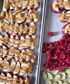 apples and raspberries are arranged on trays for dessert or appetizers