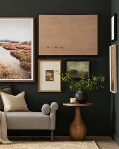 a living room with green walls and pictures on the wall next to a couch, coffee table