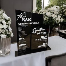 the table is set up for a wine tasting event with white flowers in vases