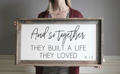 a woman holding a sign that says and so together they built a life they loved