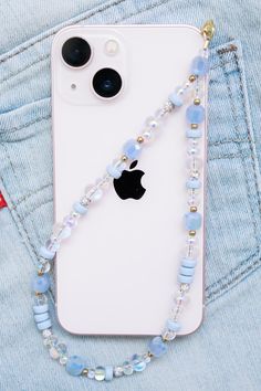 an iphone case with a beaded lanyard attached to it, sitting in the pocket of someone's jeans