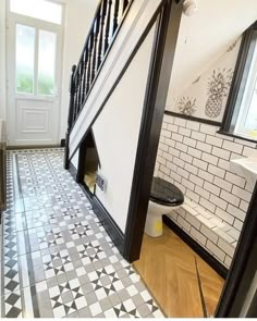 an open door leading to a bathroom with black and white tiles