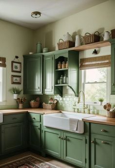 a kitchen with green cabinets and white sink