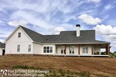 a large white house sitting on top of a grass covered field