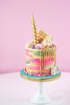 a colorful cake decorated with an unicorn horn