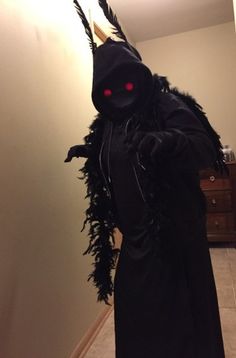 a person in a black costume with red eyes