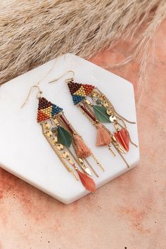 Elevate your style with our Boho Dreams Beads & Feathers Cascade Earrings. These chic earrings feature a delightful combination of vibrant beads and playful feathers, creating a bohemian-inspired cascade that adds flair to any outfit. Embrace the carefree spirit of boho fashion with these stylish earrings – perfect for expressing your unique style and making a statement effortlessly.#completeyourlook #lovemyleto 65% Iron 20% Glass 4% Natural Stone 3% Feather 3% Zinc 3% Polyester Thread 2% CCB Handcrafted in India Dangling Bead Tassel Earrings For Festivals, Bohemian Adjustable Tassel Earrings With Dangling Beads, Bohemian Dangle Earrings With Feathers, Bohemian Dangle Feather Earrings, Festival Tassel Earrings With Dangling Beads, Bohemian Beaded Earrings With Latkans For Parties, Cascade Earrings, Stylish Earrings, Chic Earrings