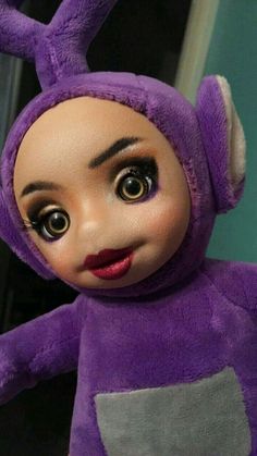 a close up of a stuffed animal wearing a purple outfit