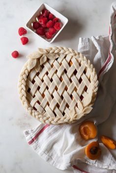 an uncooked pie sitting on top of a white table next to a napkin