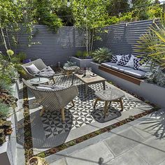 an outdoor seating area with chairs, tables and plants