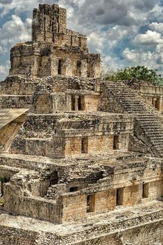 an ancient building in the middle of a cloudy sky