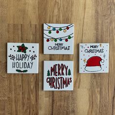 three christmas cards on a wooden surface