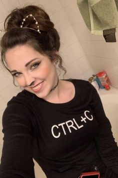 a woman sitting in a bathtub wearing a black shirt with the word ctrllc on it