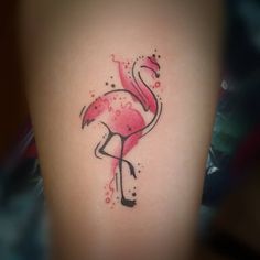 a pink flamingo tattoo on the left thigh and right leg with watercolor splatters