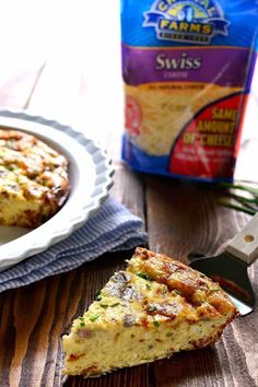 a slice of quiche on a plate next to a bag of chips and a knife