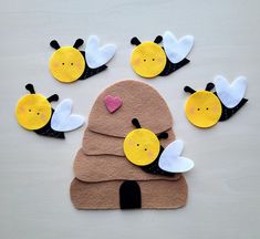 felt bees with hearts on them sitting in the shape of a beehive