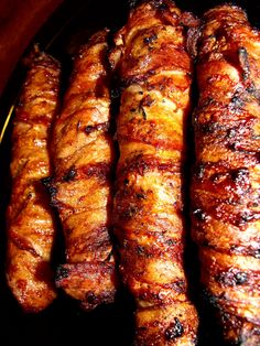 four skewers of meat sitting on top of a black plate next to each other