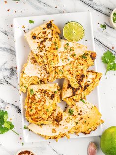 chicken with cilantro and limes on a white plate next to some seasoning