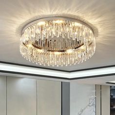 a chandelier hanging from the ceiling in a room with white walls and marble flooring