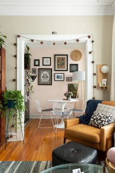 a living room filled with furniture and pictures hanging on the wall above a dining table