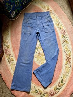 These are so dope! 1970's Sears light wash denim flared jeans Snap button zipper fly 2 snap button pockets on front and on the booty Flared Soft denim Several stain spots on front pockets and some on the back Photos reveal staining Cotton material Tag reads size 29/31 Fit more like a 28 in waist Measurements are approximate and taken flat so please double waist and hips for more accurate sizing Waist: 14 in Hips: 16 in Rise: 11 in Inseam: 30 in Length: 40.5 in All sales are final Thanks for chec Vintage Blue Wide Leg Cargo Jeans, Vintage High Waist Denim Cargo Jeans, Vintage Straight Leg Cargo Jeans For Spring, Vintage Denim Blue Cargo Jeans For Spring, Vintage High-waist Denim Cargo Jeans, Vintage Cotton Cargo Jeans For Spring, Vintage Cargo Jeans In Denim Blue For Spring, Retro Medium Wash Pants With Pockets, Vintage Light Wash Bottoms For Fall