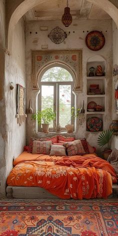 a bed sitting under a window in a bedroom next to a rug and potted plant