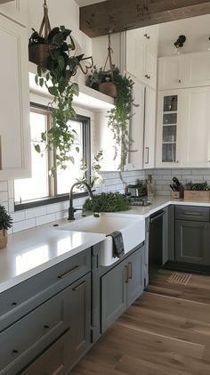 a kitchen filled with lots of white cabinets and counter top space next to a window