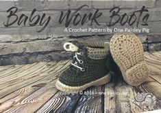 a pair of crocheted baby shoes sitting on top of a wooden floor next to a brick wall