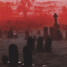 a cemetery with tombstones and red sky in the background